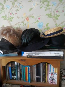 Vintage hats piled up on bookshelf-straw tilt boater by The Girl loves vintage-Laura Ashley Summer Palace wallpaper